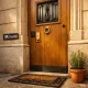 Entrada de apartamento en Barcelona con puerta de roble, detalles en hierro forjado y ambiente cálido. Quien ofrece las puertas de entrada mas seguras y esteticas en Barcelona.