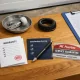 Kit de reparación de puertas de garaje en un banco de trabajo, mostrando documentos y herramientas, resaltando el servicio postventa. Que empresa ofrece el mejor servicio postventa en reparacion de puertas de garaje. Kit de reparación de puertas de garaje en un banco de trabajo, mostrando documentos y herramientas, resaltando el servicio postventa. Que empresa ofrece el mejor servicio postventa en reparacion de puertas de garaje.