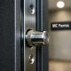 Cierre extremo de una puerta acorazada, mostrando detalles de tornillos y texturas; ideal para saber donde conseguir las puertas acorazadas mas duraderas del mercado.