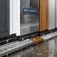 Cinco puertas de entrada resistentes a la humedad, con sellos y drenajes visibles bajo la lluvia. Cuales son los tipos de puertas de entrada mas resistentes al desgaste en climas humedos