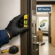 Técnico nivela premarco de puerta blindada en entrada española; servicios de instalación de puertas rápidos y eficientes en España.