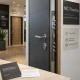 Puerta blindada grafito en showroom espau00f1ol, con herrajes visibles y documentos; Donde encontrar puertas blindadas de diseno moderno